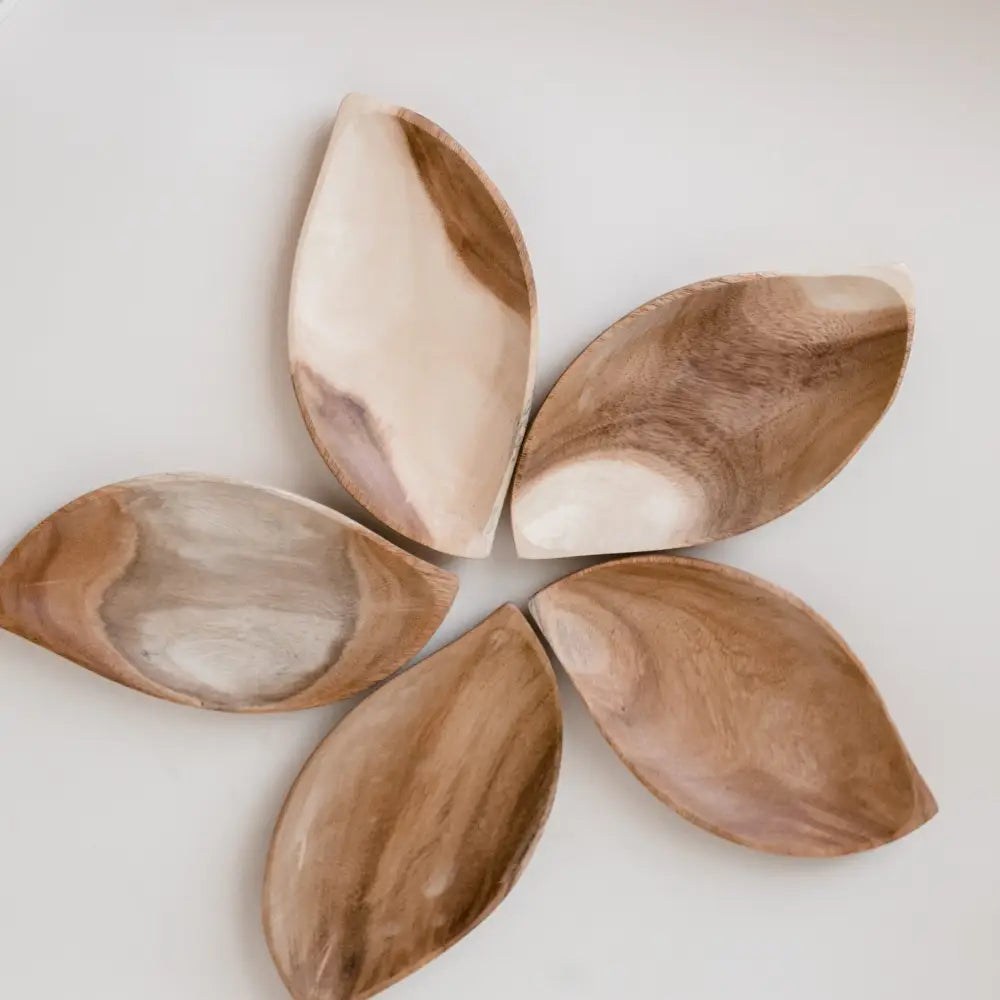 Flower-shaped arrangement of five wooden or ceramic petal-like pieces.