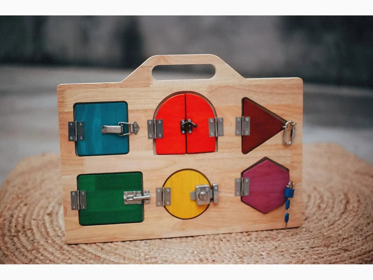 Wooden children’s toy with colorful shapes and latches for learning fine motor skills.