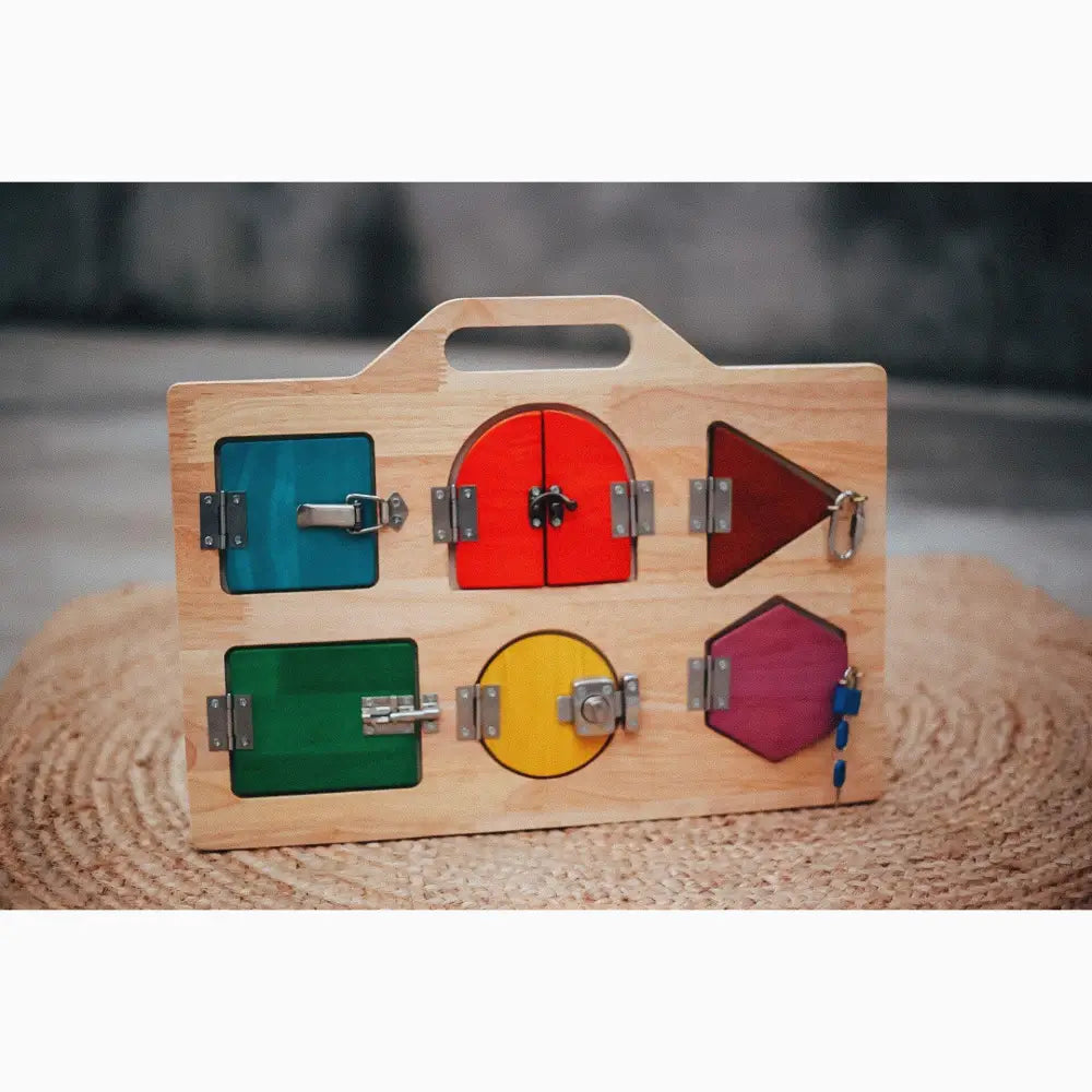 Wooden children’s toy with colorful shapes and latches for learning fine motor skills.