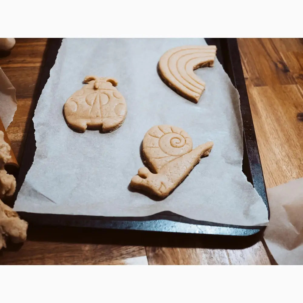 Unbaked cookie dough shapes on parchment paper.