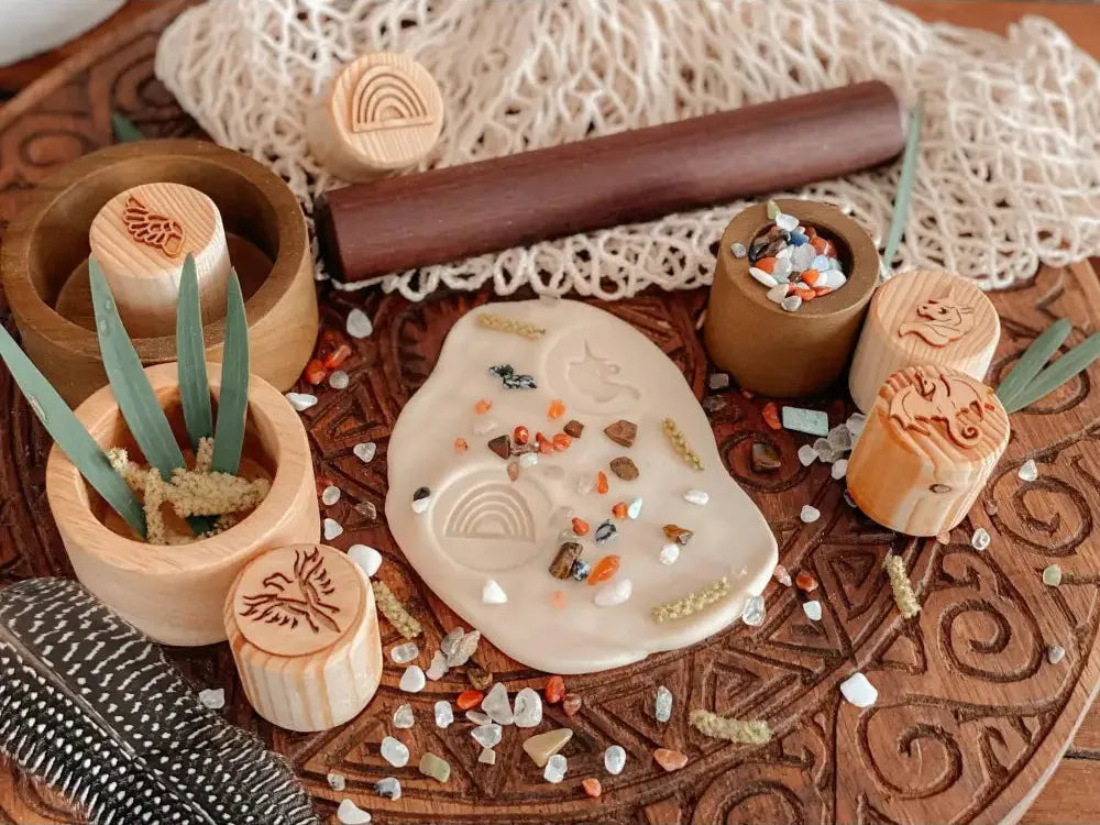 Clay or ceramic slab with various stamped and textured designs, surrounded by tools and decorative elements.