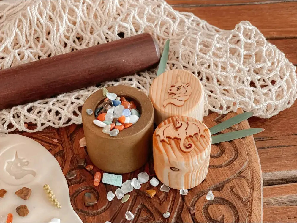 Wooden container with carved cat face holding colorful beads or stones.
