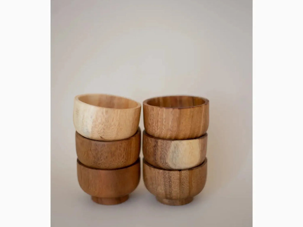 Set of six wooden bowls or cups with alternating light and dark wood tones.