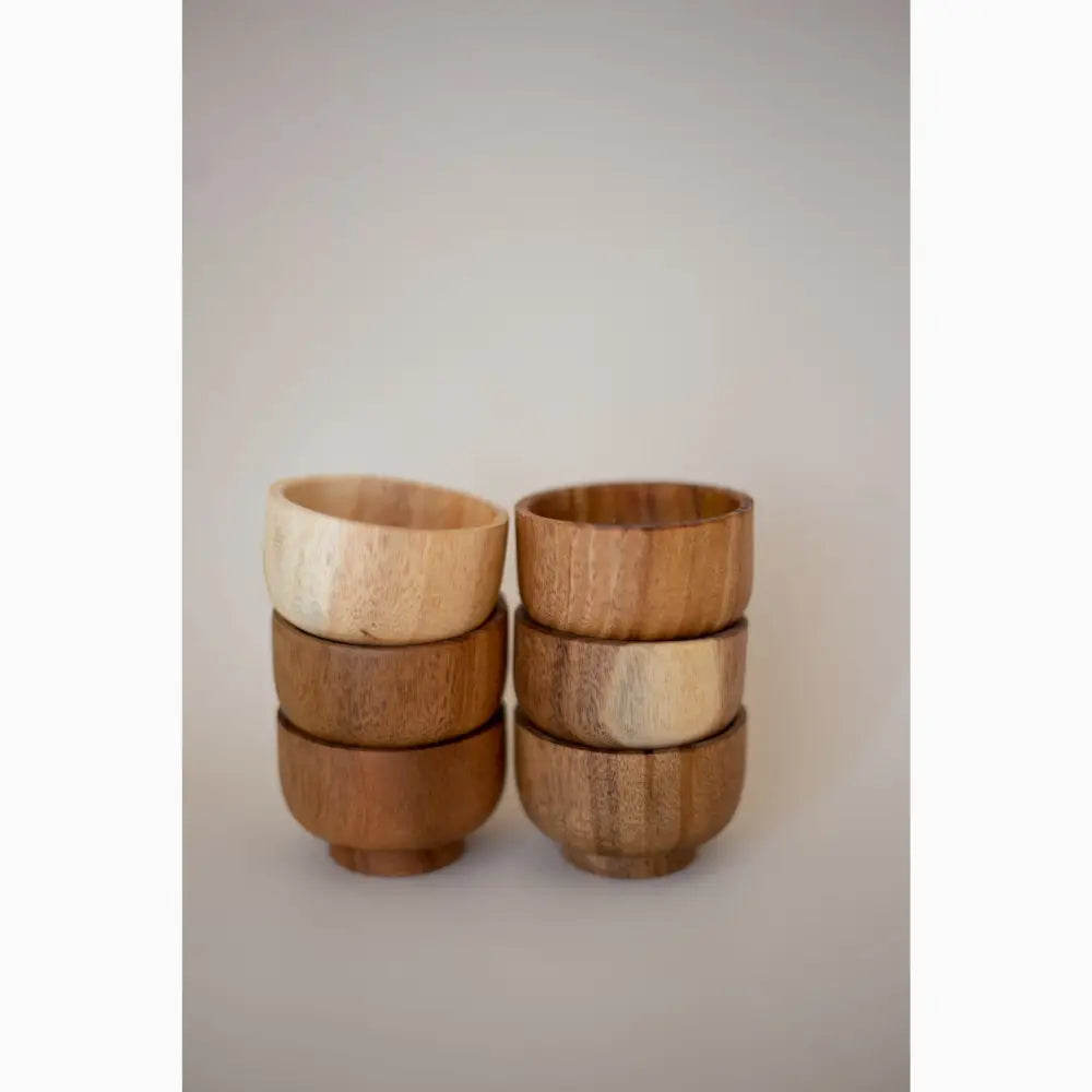 Set of six wooden bowls or cups with alternating light and dark wood tones.