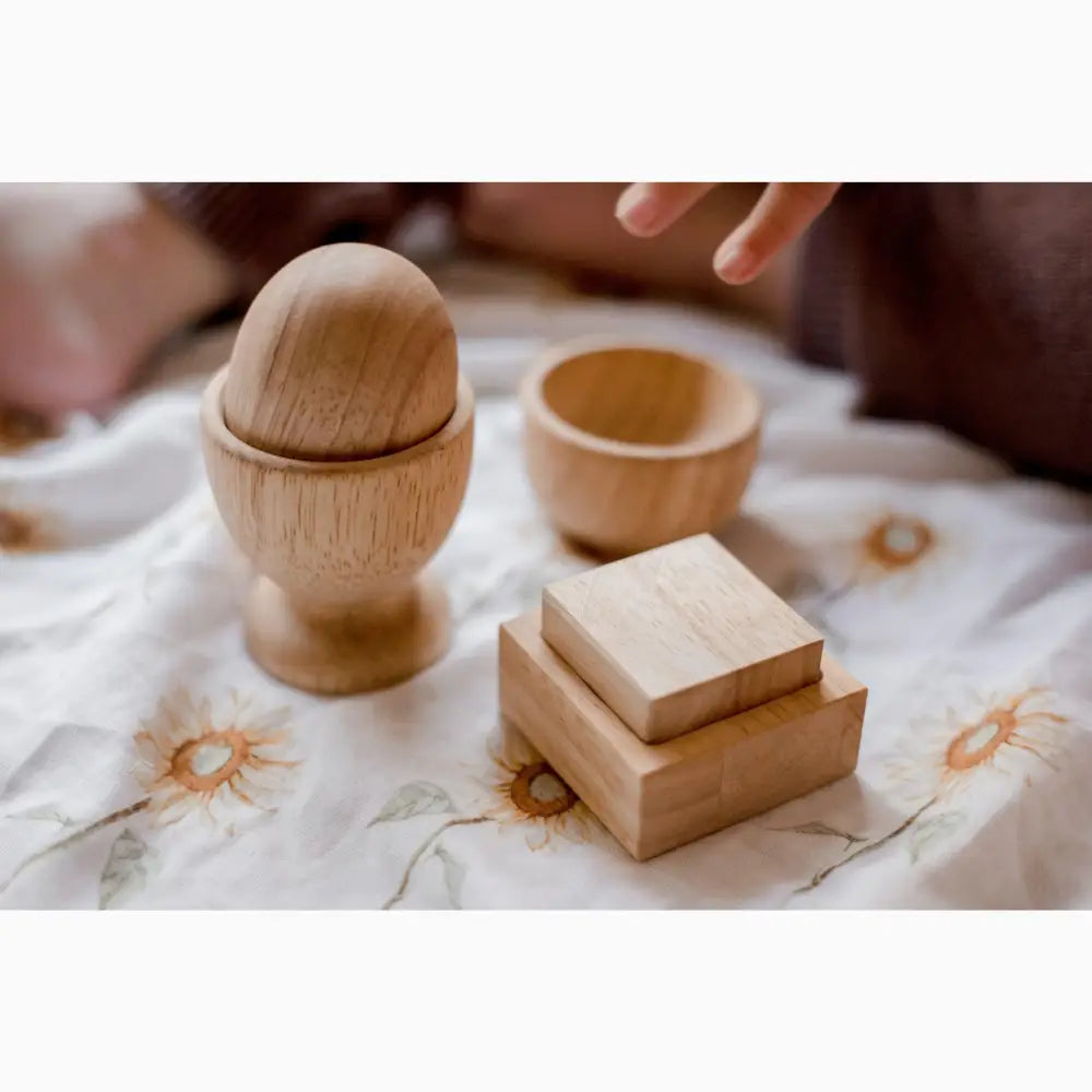 Wooden egg cup with accompanying small wooden boxes or containers.