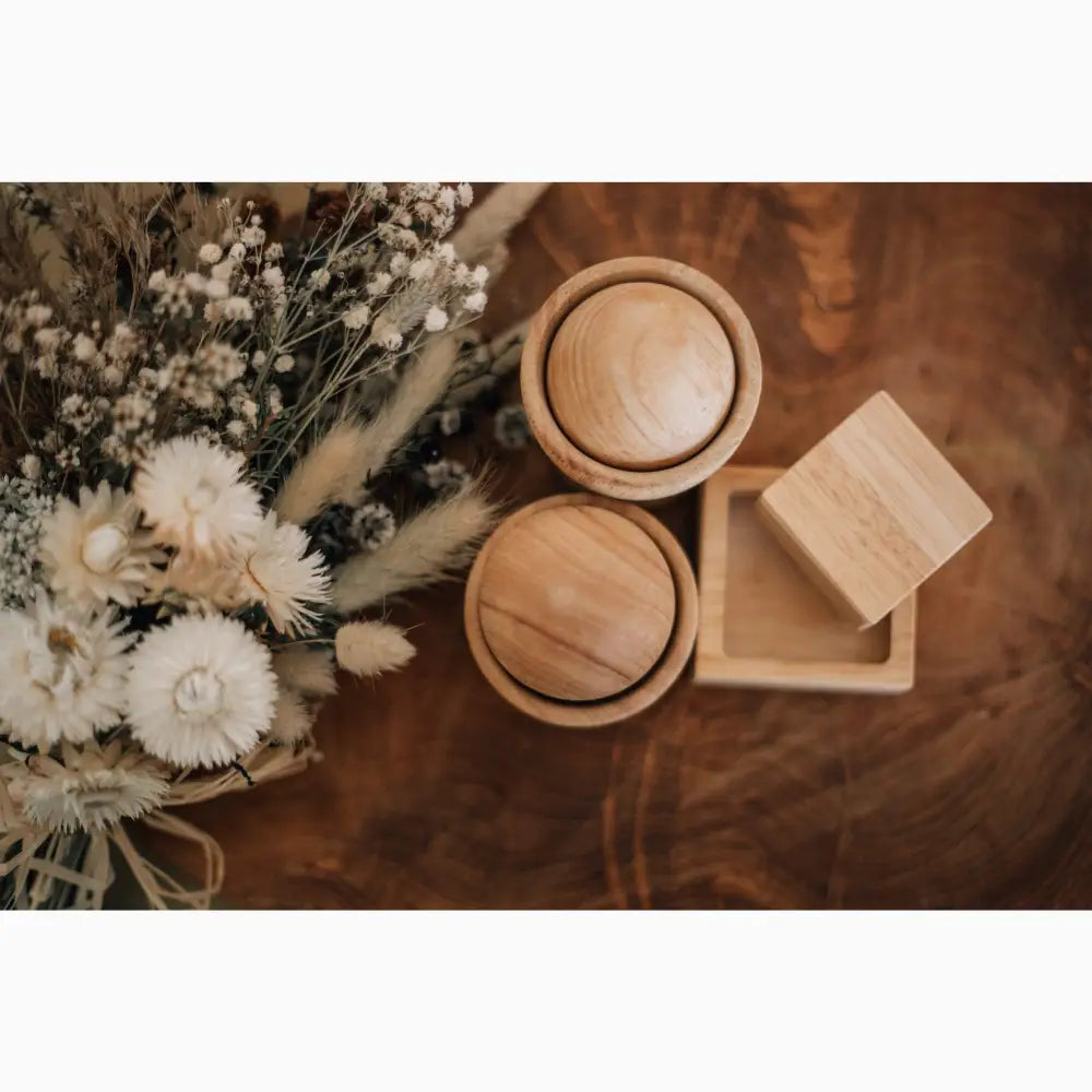 Bouquet of dried flowers alongside wooden boxes or containers.