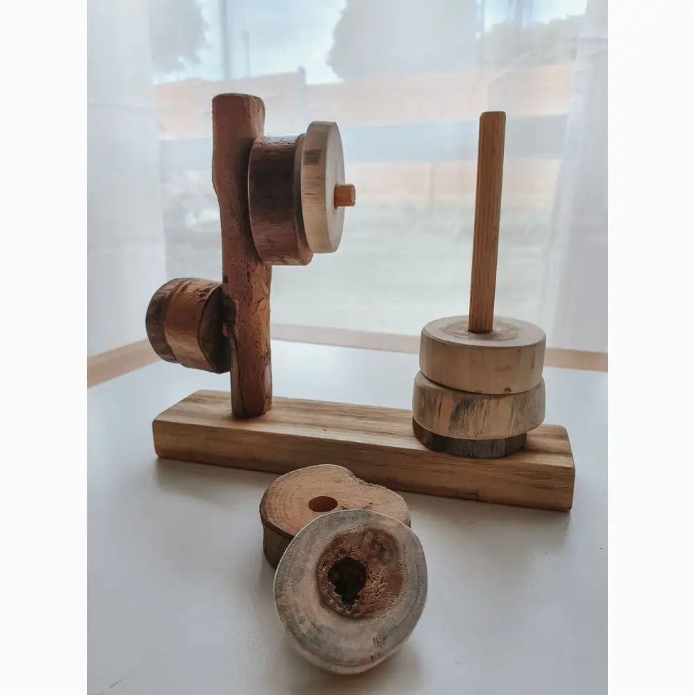 Wooden toy or puzzle with circular pieces and vertical posts on a base.