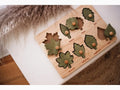 Wooden puzzle board with leaf-shaped cutouts and pieces.
