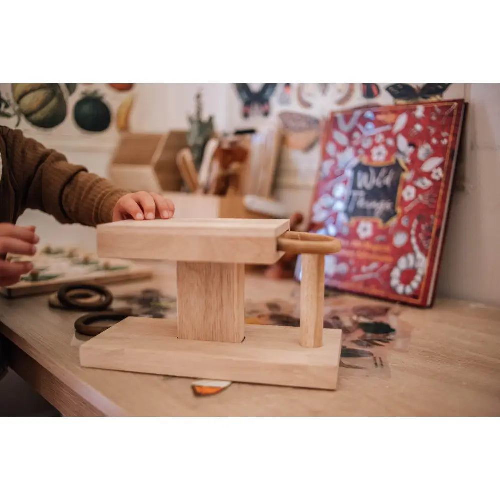 Wooden balance board or wobble board with a rectangular base and cylindrical fulcrum.