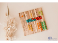 Wooden counting board with colorful beads arranged in rows next to numbers.