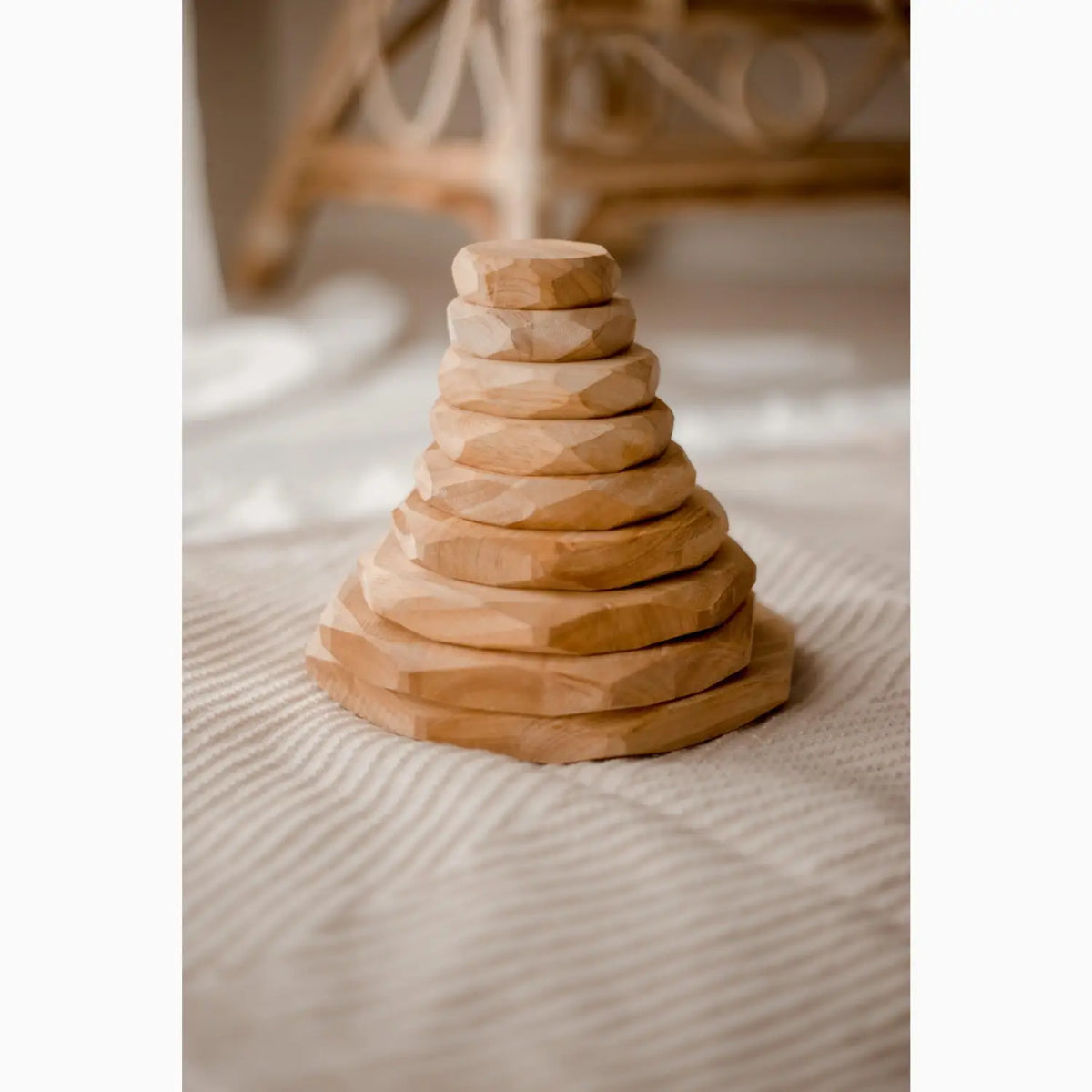 Wooden stacking toy with circular discs arranged in a pyramid shape.