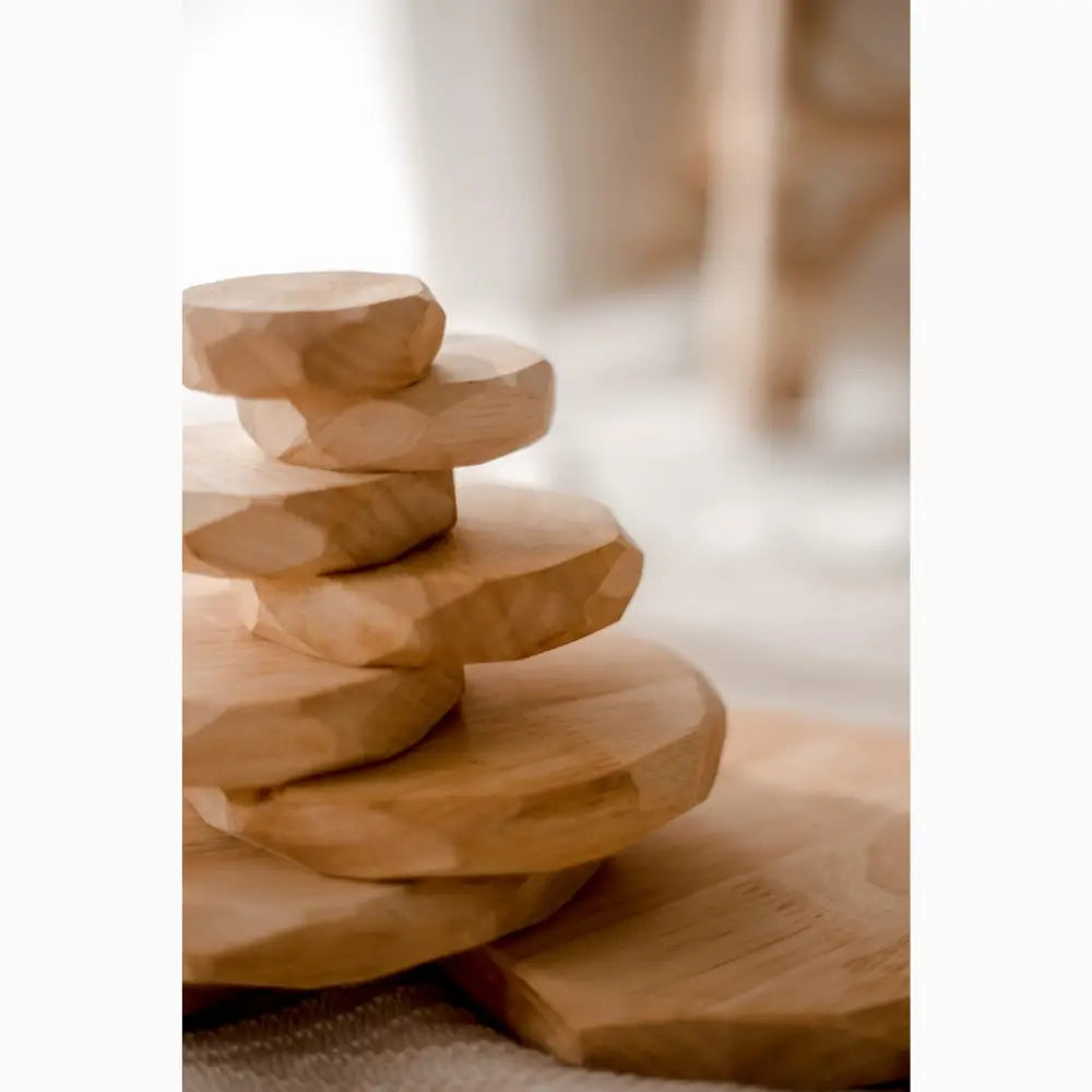 Stack of smooth wooden discs or pebbles balanced on top of each other.