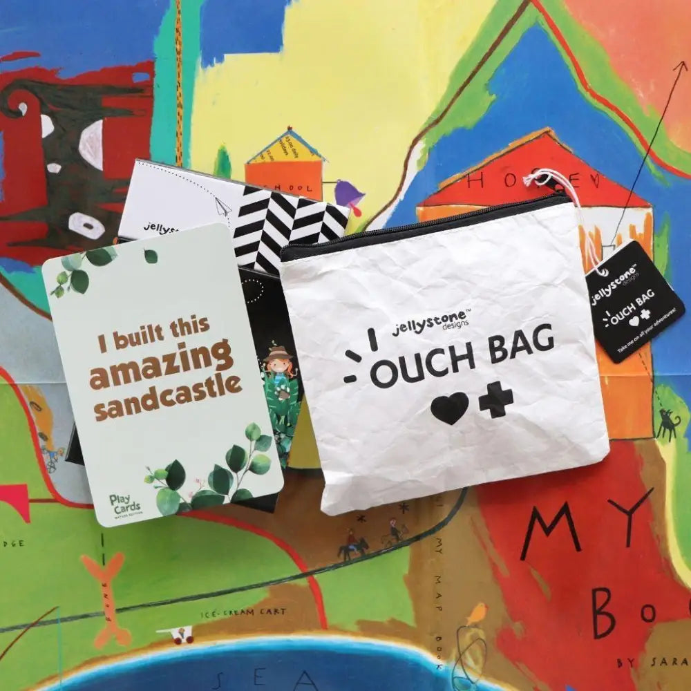 White canvas pouch labeled ’OUCH BAG’ with a heart and plus sign symbol.