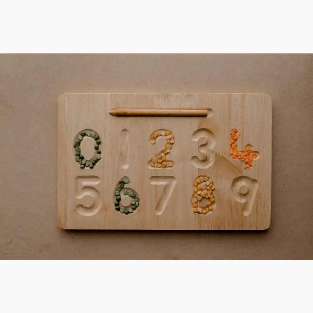 Wooden number board with carved digits filled with colorful beans or seeds.