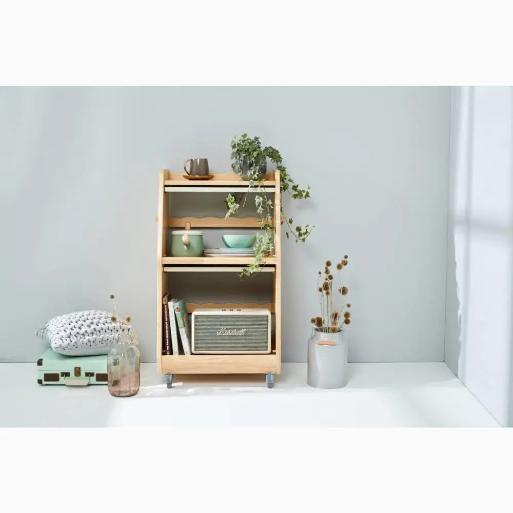 Wooden bookshelf with three shelves displaying various decorative objects and plants.