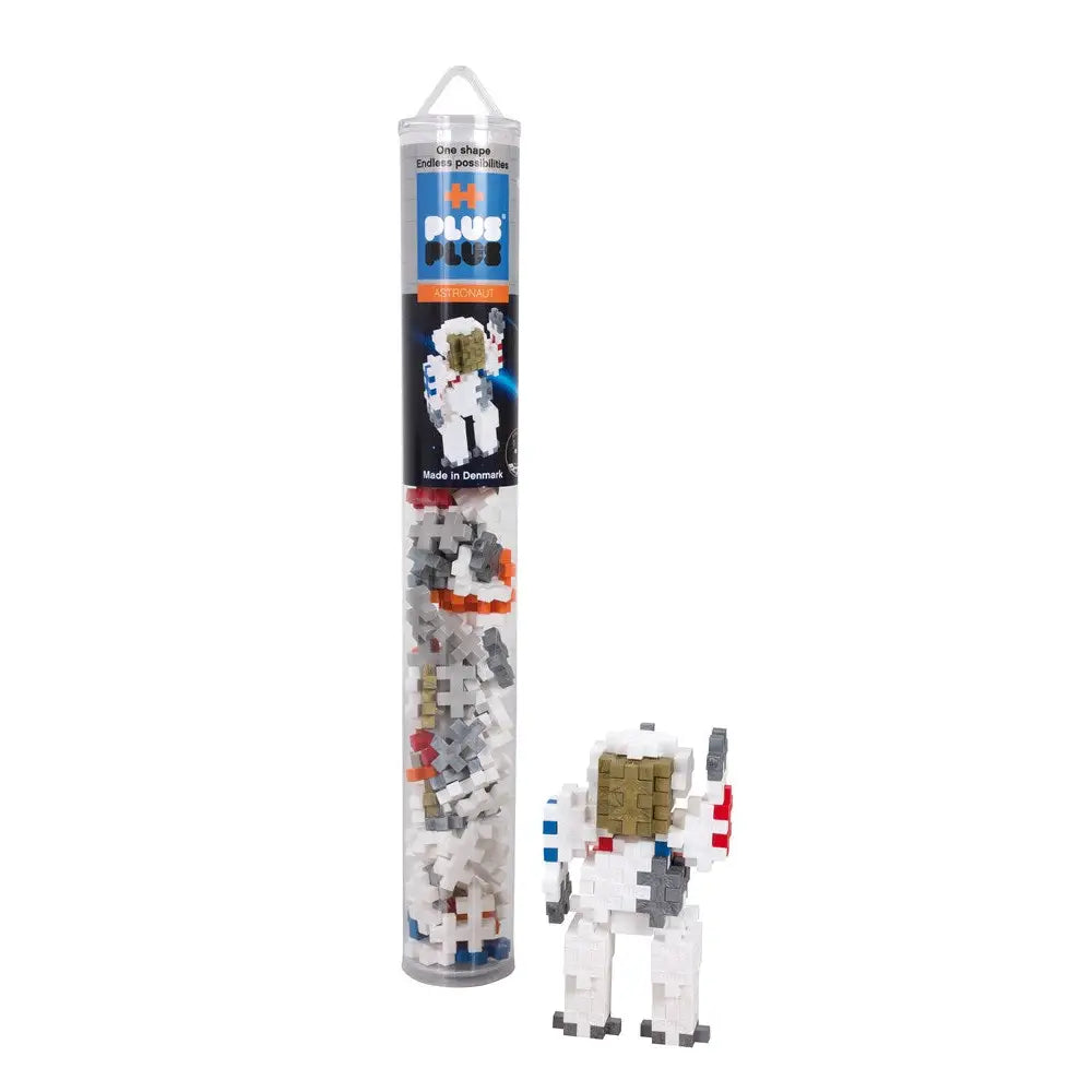 Clear plastic tube containing a space-themed building block set with an astronaut figure visible.