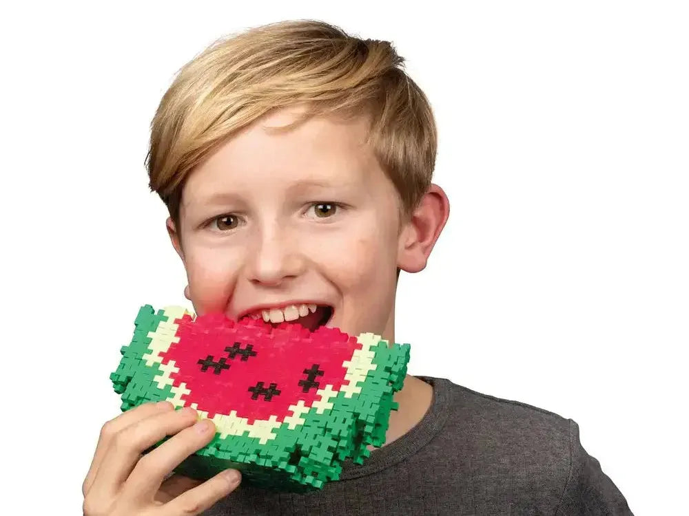 Smiling child holding a pixelated watermelon slice made of blocks.