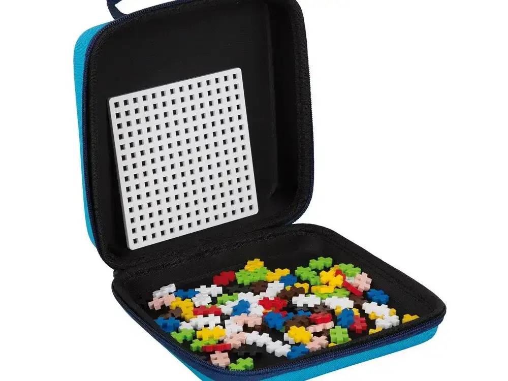Carrying case containing colorful plastic building blocks and a perforated board.