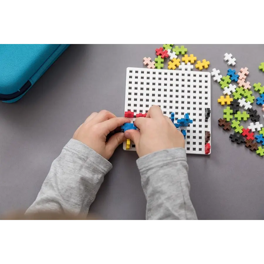 Pegboard with colorful plastic pieces being inserted by hands.