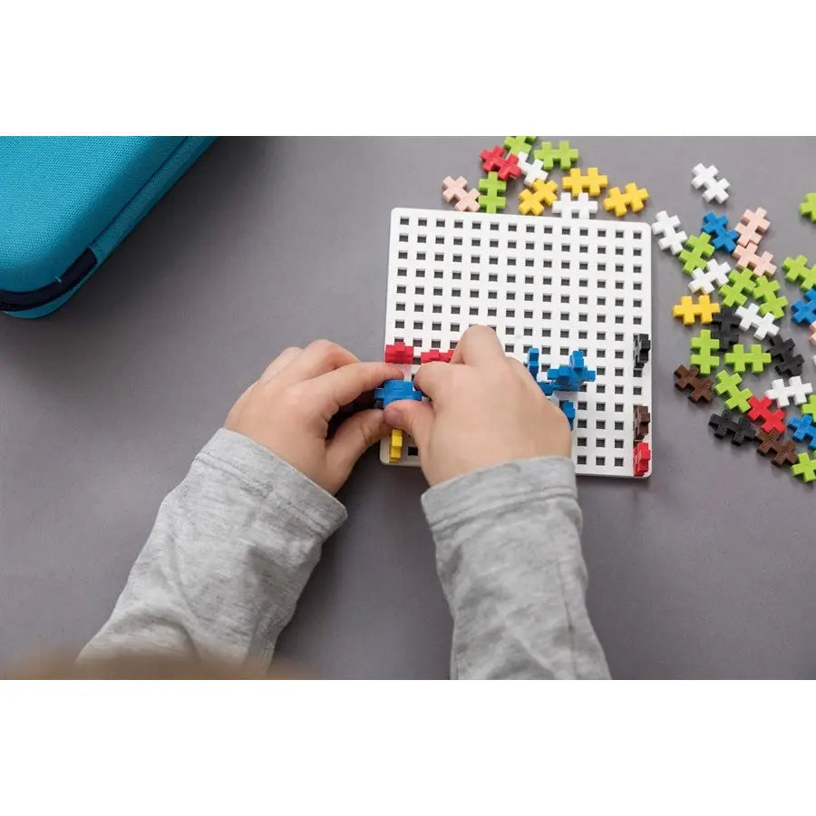 Pegboard with colorful plastic pieces being inserted by hands.