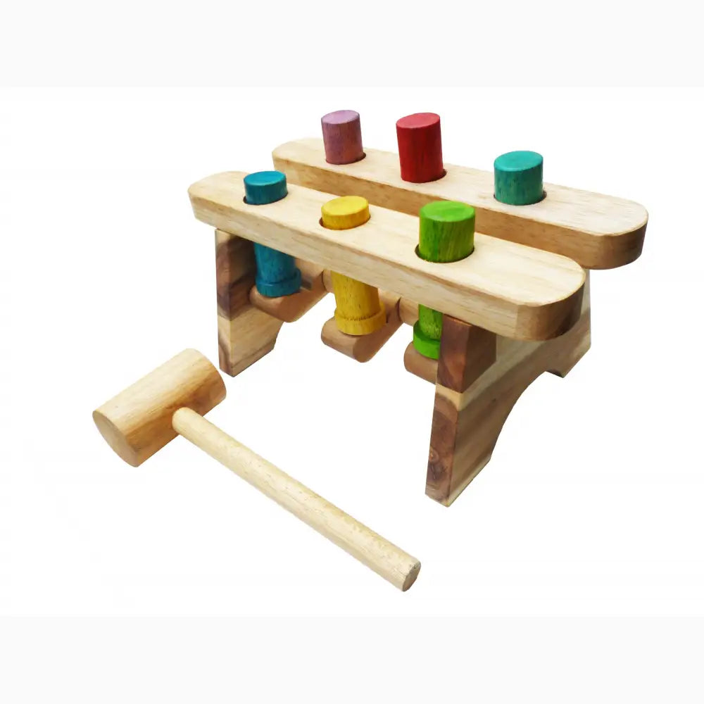 Wooden toy pounding bench with colorful cylindrical pegs and a hammer.