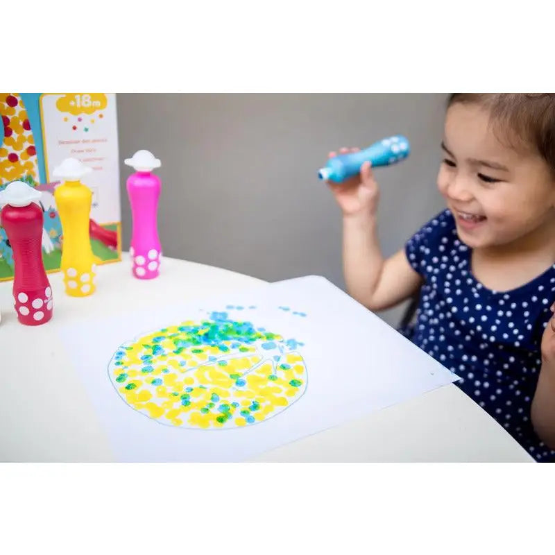 Child playing with colorful dot markers on paper.