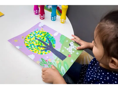 Colorful tree artwork being created by a child using paper mosaic technique.