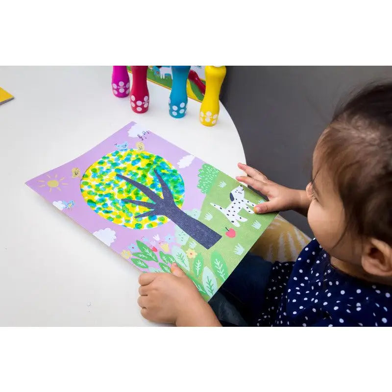 Colorful tree artwork being created by a child using paper mosaic technique.