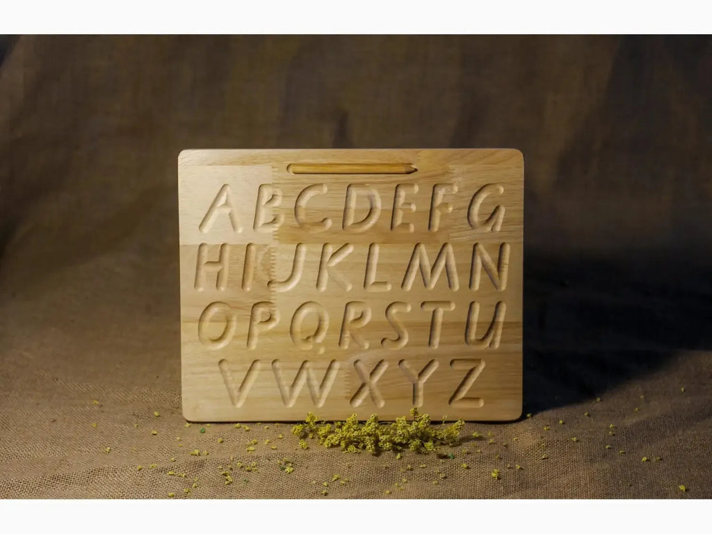 Wooden alphabet tracing board with carved uppercase letters.