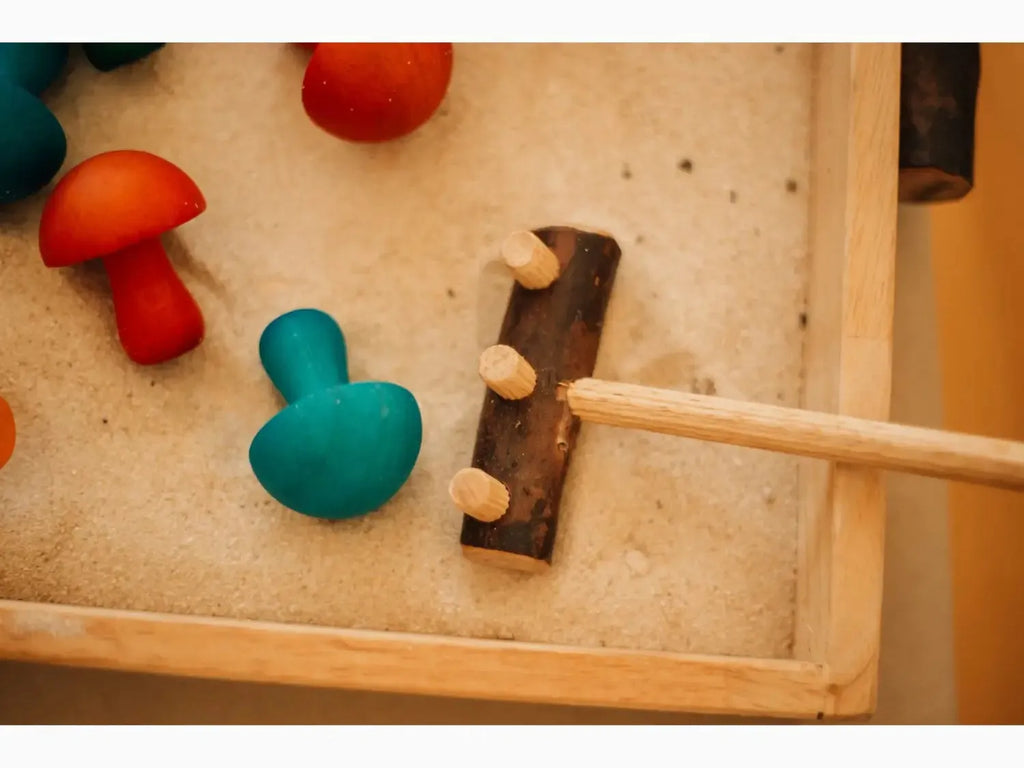 Wooden hammer toy with colorful pegs on a board.
