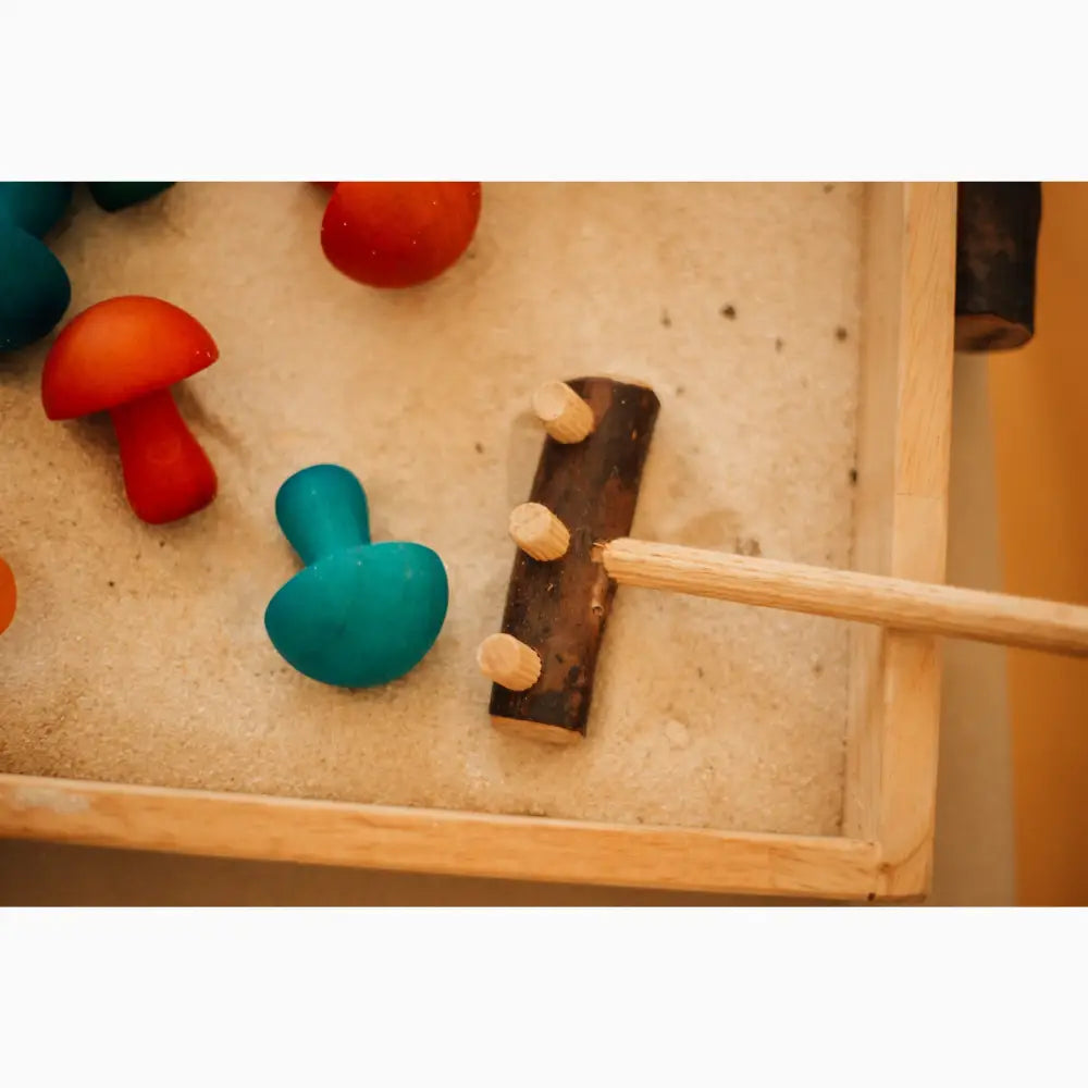 Wooden hammer toy with colorful pegs on a board.