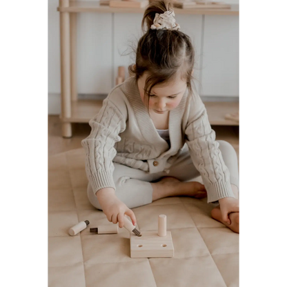 Child playing with wooden toy tools.