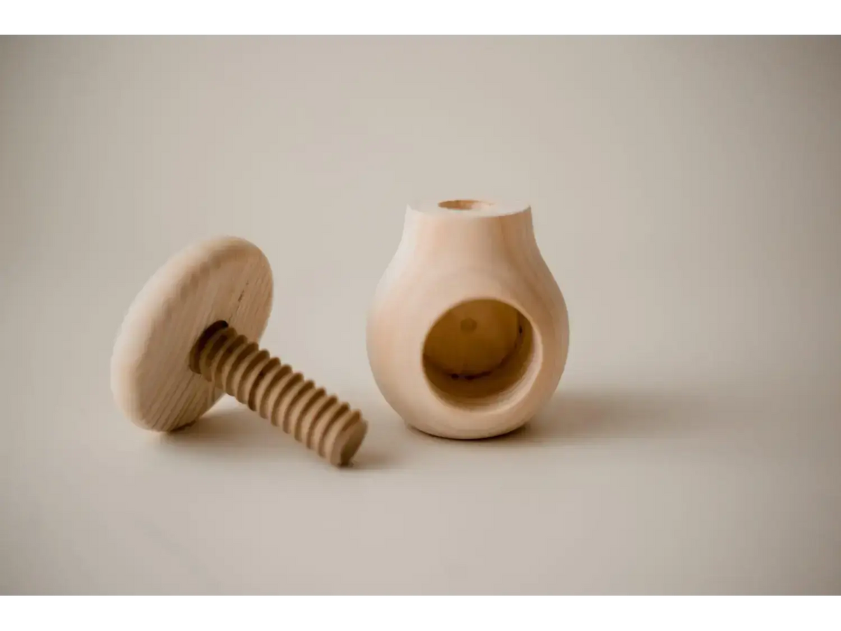 Wooden nutcracker with a screw mechanism and a rounded base.