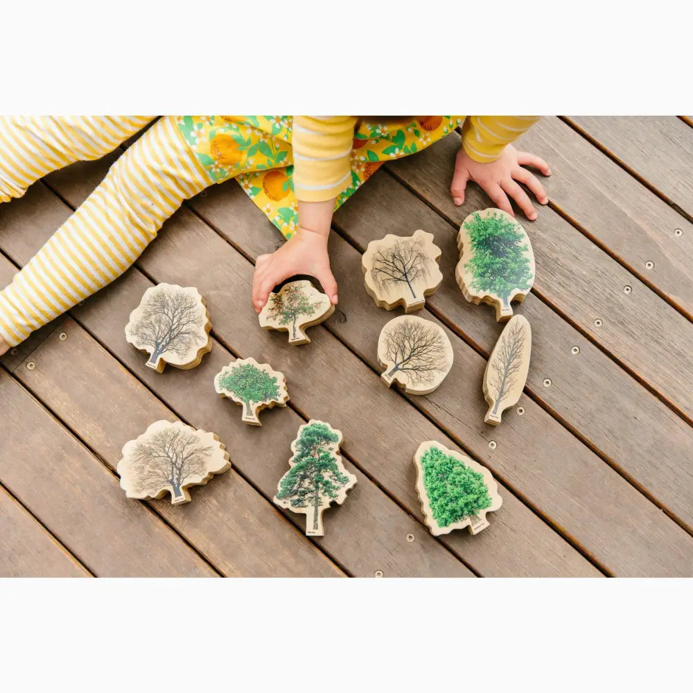 Wooden tree-shaped stamps or blocks with leaf and tree designs.