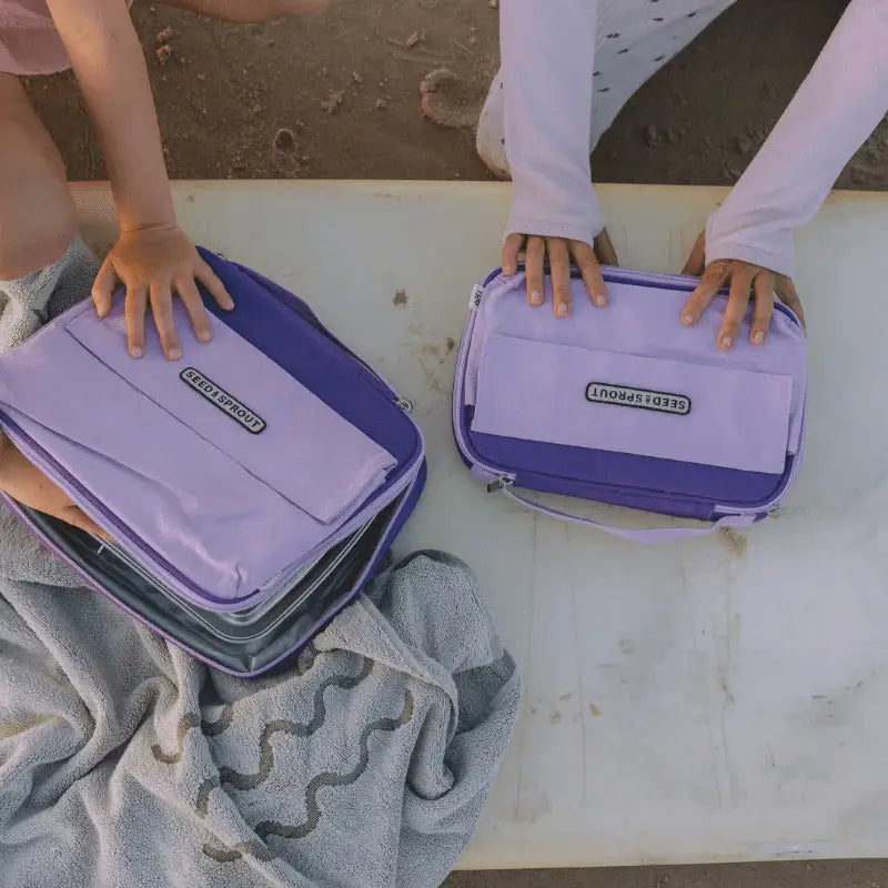 Purple lunchboxes or insulated food containers with ’Bentology’ branding.