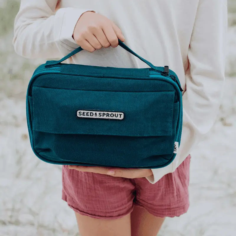 Teal-colored rectangular bag with ’Seed & Sprout’ branding and multiple compartments.