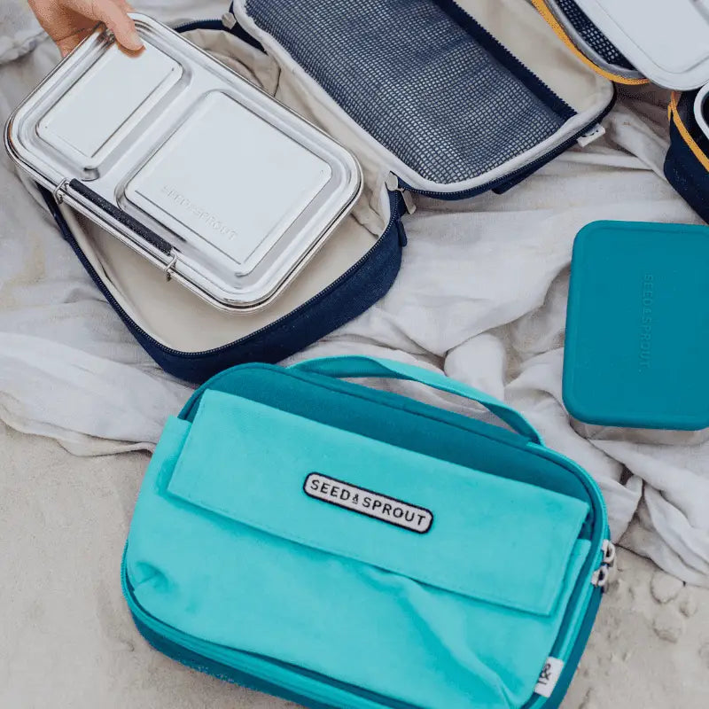 Teal-colored insulated lunch bag with ’Stasher’ branding.