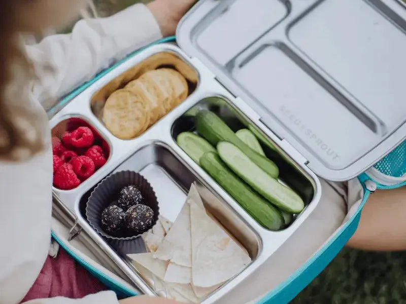 Compartmentalized lunchbox containing various healthy snacks and foods.