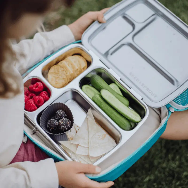 Compartmentalized lunchbox containing various healthy snacks and foods.