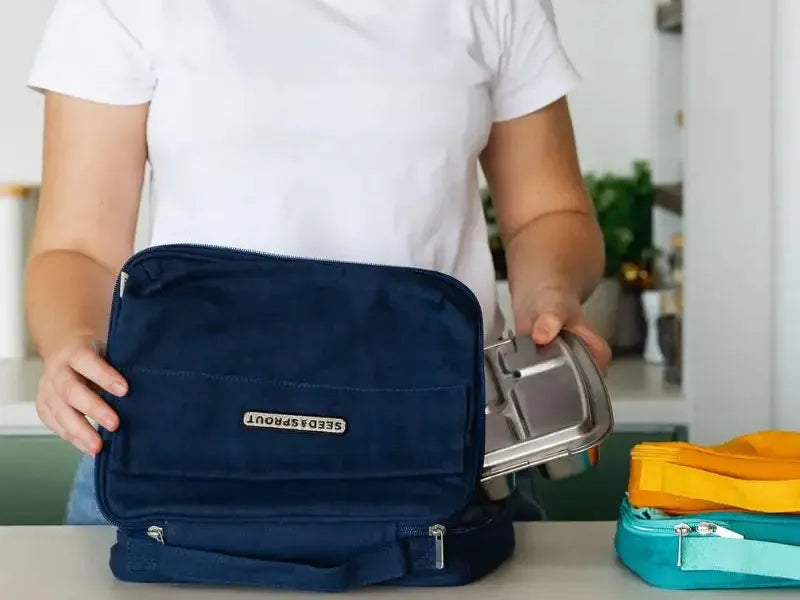 Navy blue insulated lunch bag with multiple compartments and a gold-colored logo.