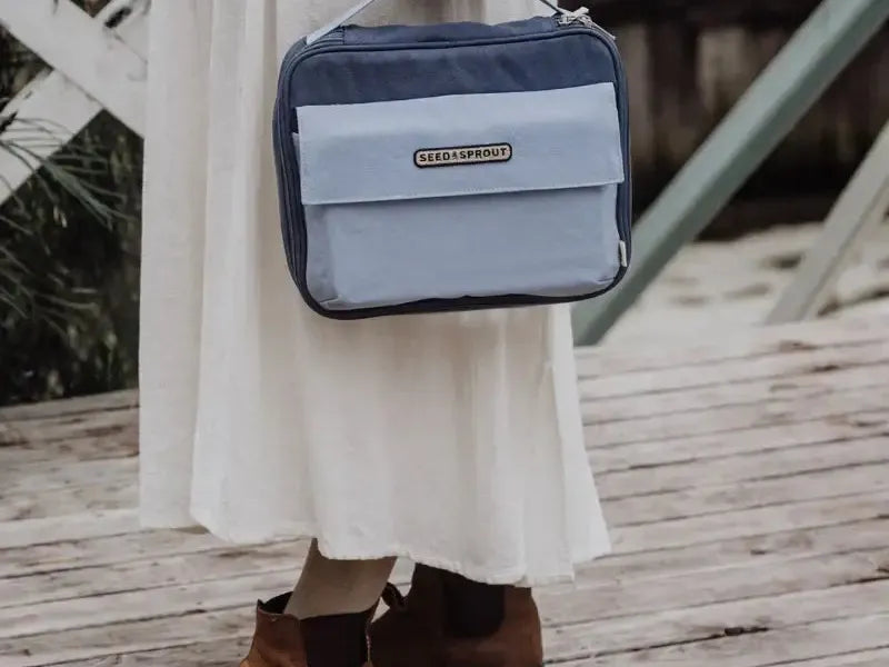 Two-toned blue rectangular bag with a handle and front pocket.