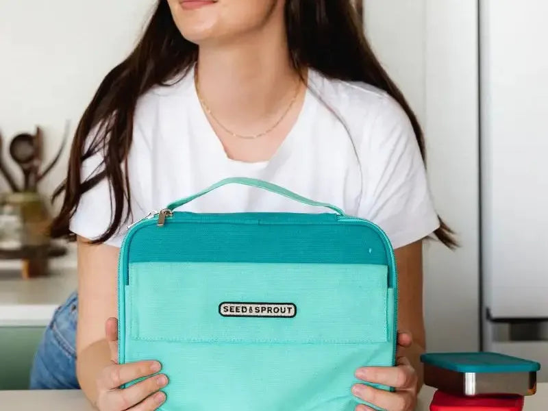 Turquoise insulated lunch bag with a handle and ’Bentgo’ branding.