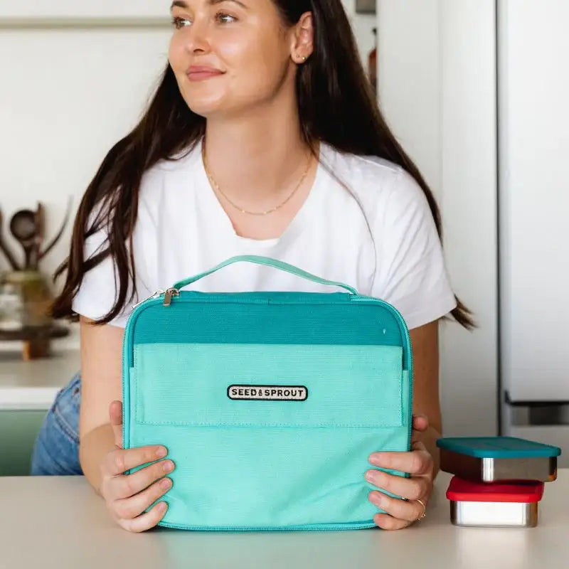 Turquoise insulated lunch bag with a handle and ’Bentgo’ branding.