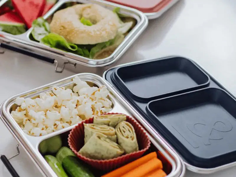 Bento-style lunch boxes containing various compartmentalized food items.