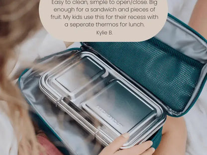 Stainless steel food container with a clear lid inside a teal insulated carrying case.