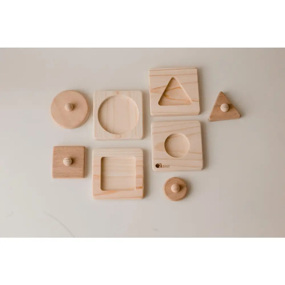 Collection of wooden geometric shapes and blocks with various cutouts and indentations.