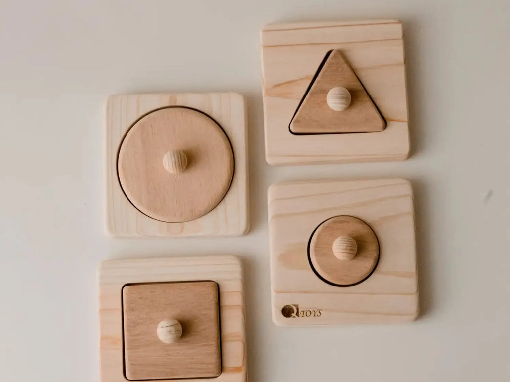 Set of wooden shape puzzles for children featuring circle, triangle, and square pieces with knobs.