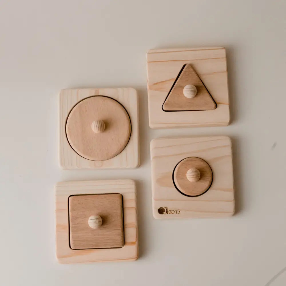 Set of wooden shape puzzles for children featuring circle, triangle, and square pieces with knobs.