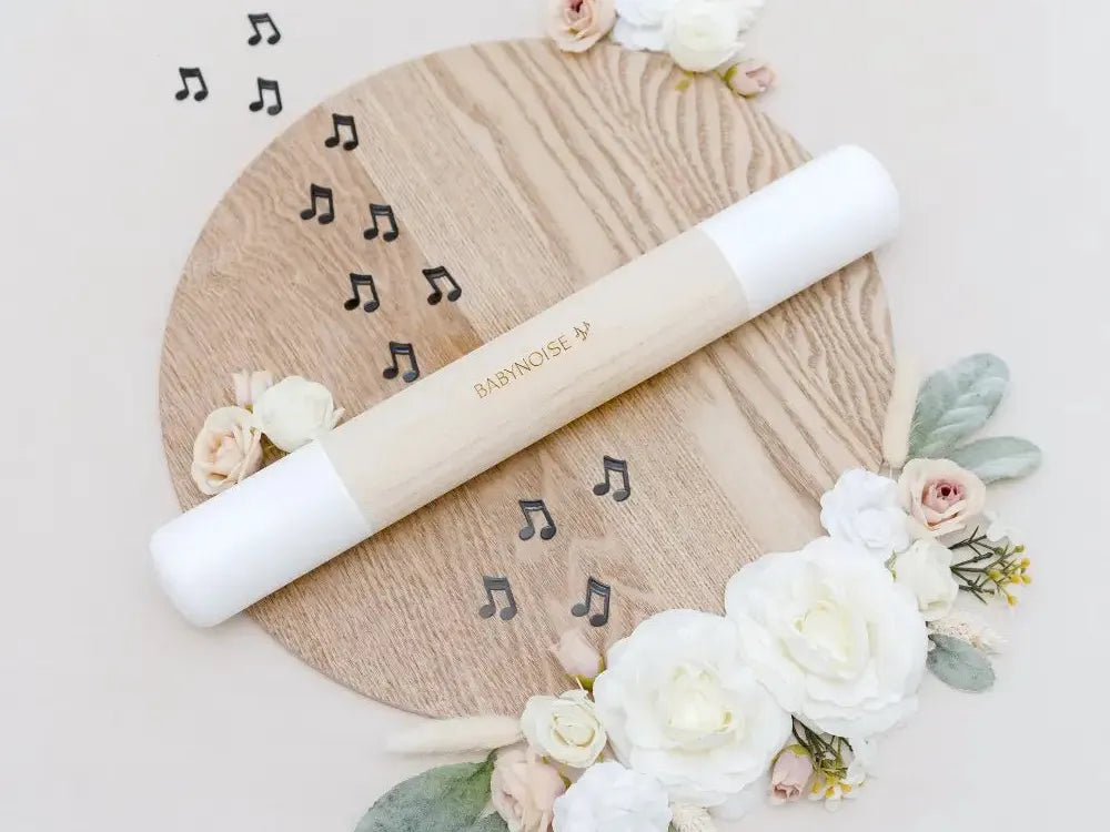 Wooden circular board decorated with flowers and musical notes, featuring a white rolling pin.