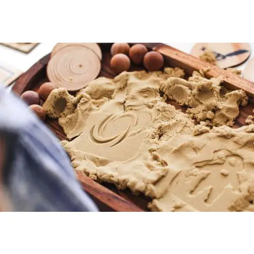 Bowl of smooth, creamy peanut butter with swirls and texture visible on its surface.